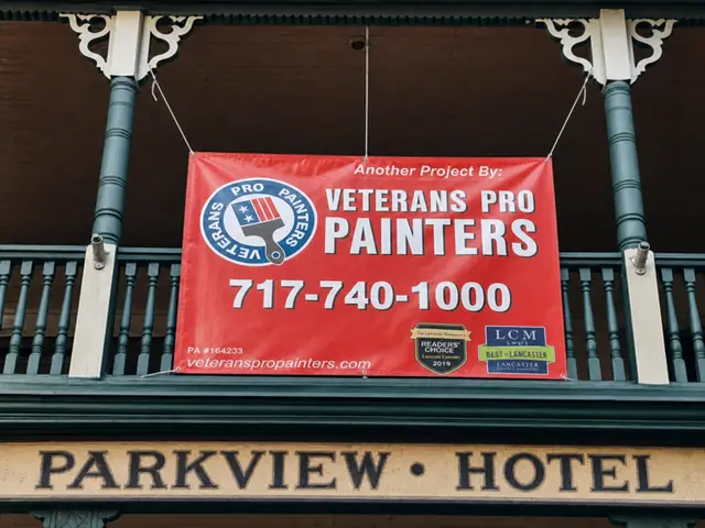 Red Veterans Pro Painters job banner tied to the green porch rail of the Parkview Hotel